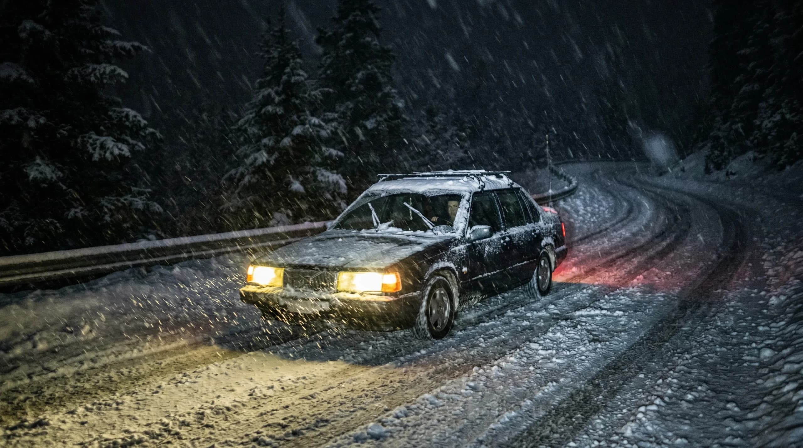 Car on snowy road at night